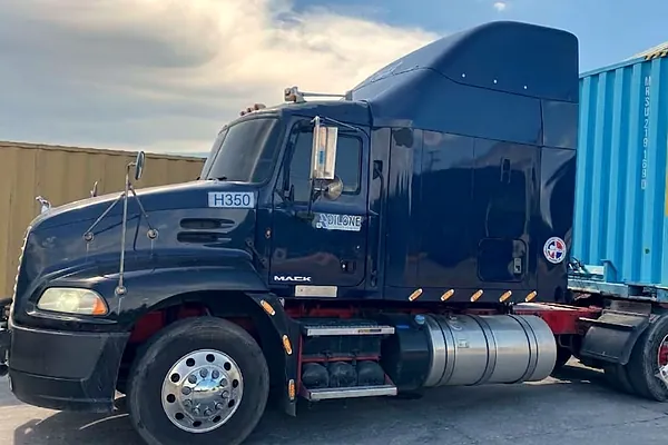 Cabezote Mack Pinnacle H350 junto a un contenedor